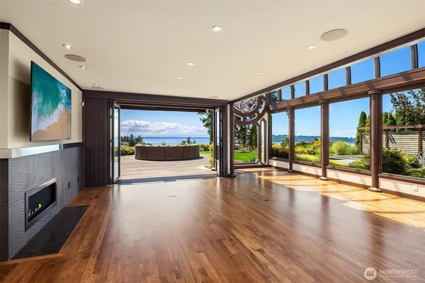 a view of an empty room with wooden floor and a fireplace