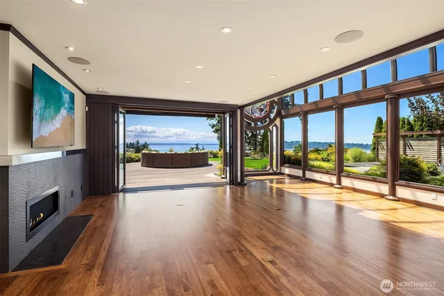 a view of an empty room with wooden floor and a fireplace