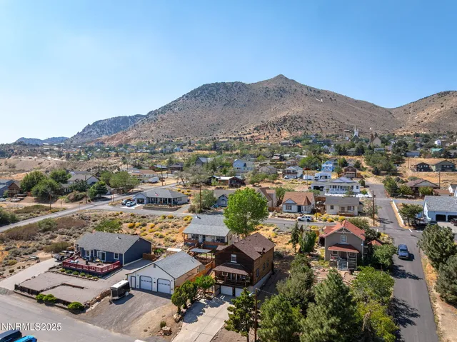 an aerial view of residential houses with outdoor space and trees