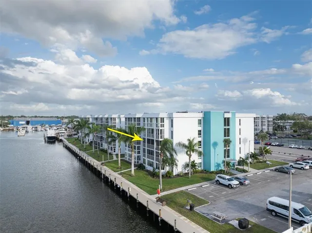 an aerial view of a house with swimming pool water view and buildings in the background