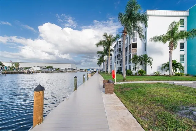 a view of a lake with a yard and large trees
