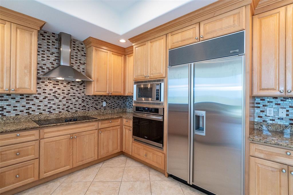 1375 Beach Road, Unit 210 Englewood, FL 34223 - Photo 21 of 49 a kitchen with granite countertop stainless steel appliances a sink stove and refrigerator
