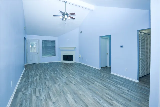 a view of empty room with wooden floor and fireplace