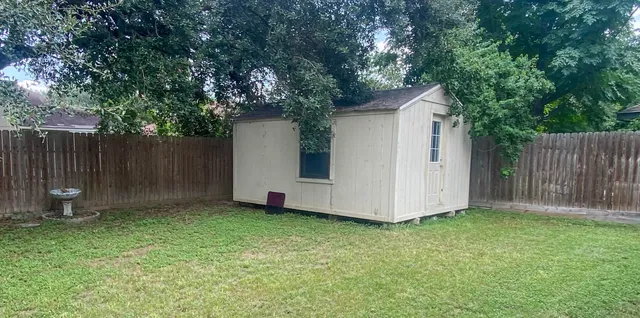 a white house that has tree in front of it