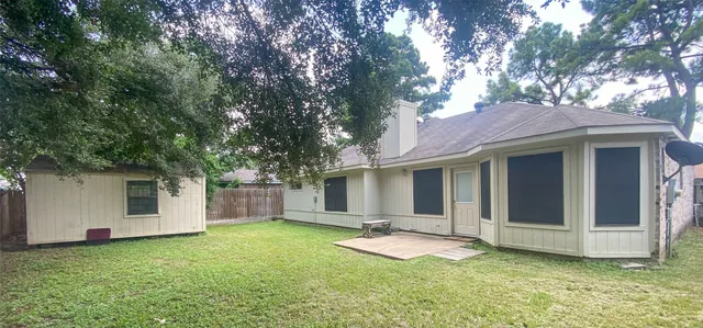 a view of a house with a yard and tree
