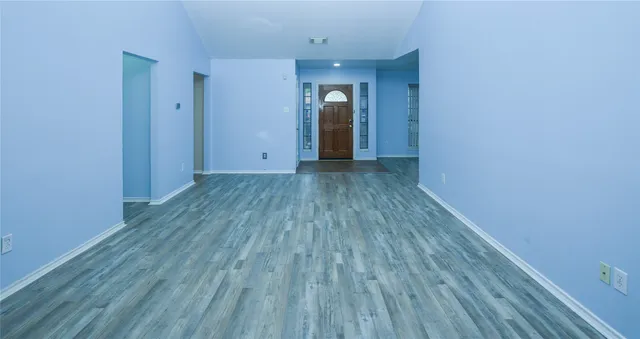 a view of a room with wooden floor and window