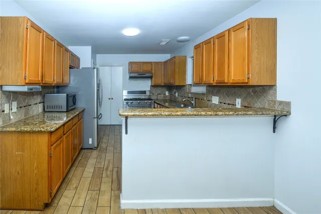 a kitchen with stainless steel appliances granite countertop a sink a stove and a refrigerator