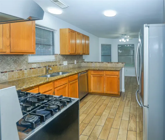a kitchen with stainless steel appliances granite countertop a sink stove and cabinets