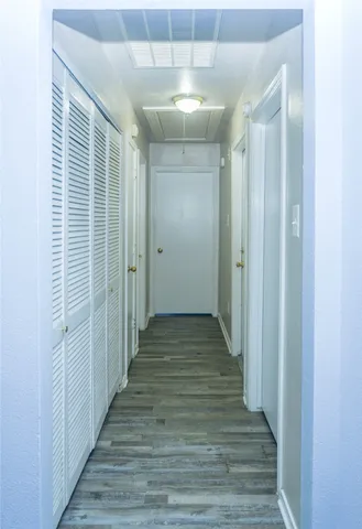 a view of a hallway with wooden floor and staircase