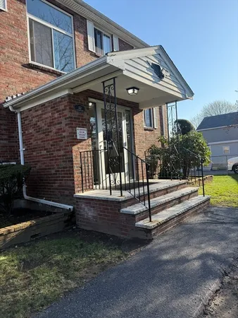 a view of house with a yard and sitting area
