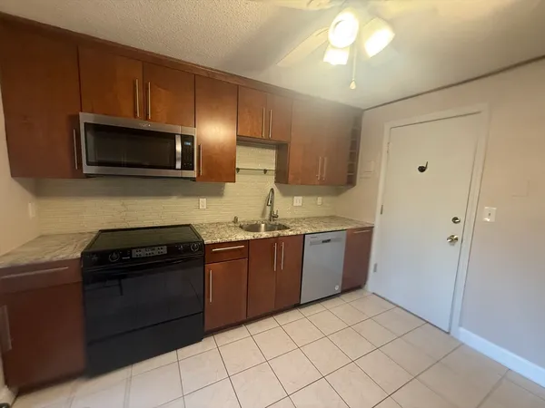 a kitchen with stainless steel appliances granite countertop a refrigerator and a stove top oven