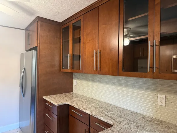 a kitchen with stainless steel appliances granite countertop cabinets and refrigerator