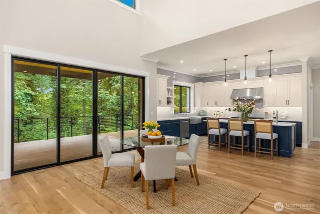 a dining room with wooden floor a rug a glass table and chairs