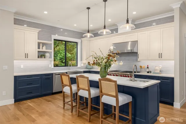a kitchen with a stove a sink a center island and cabinets