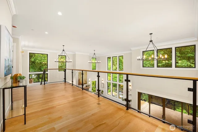 a view of an empty room with wooden floor and windows