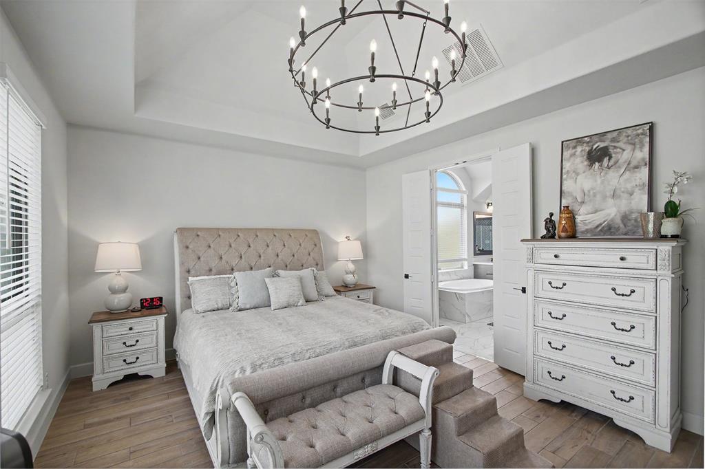 116 Derrett Lane Rhome, TX 76078 - Photo 10 of 30 a bedroom with a large bed and a chandelier