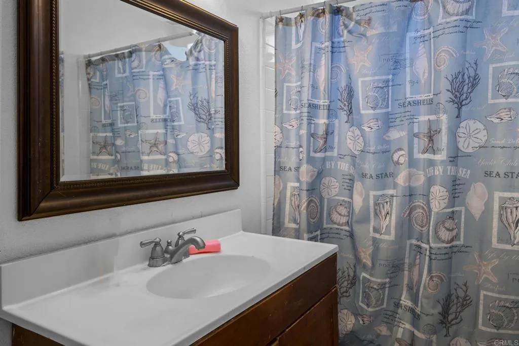 1074 Balour Drive Encinitas, CA 92024 - Photo 31 of 37 a bathroom with a sink and a mirror