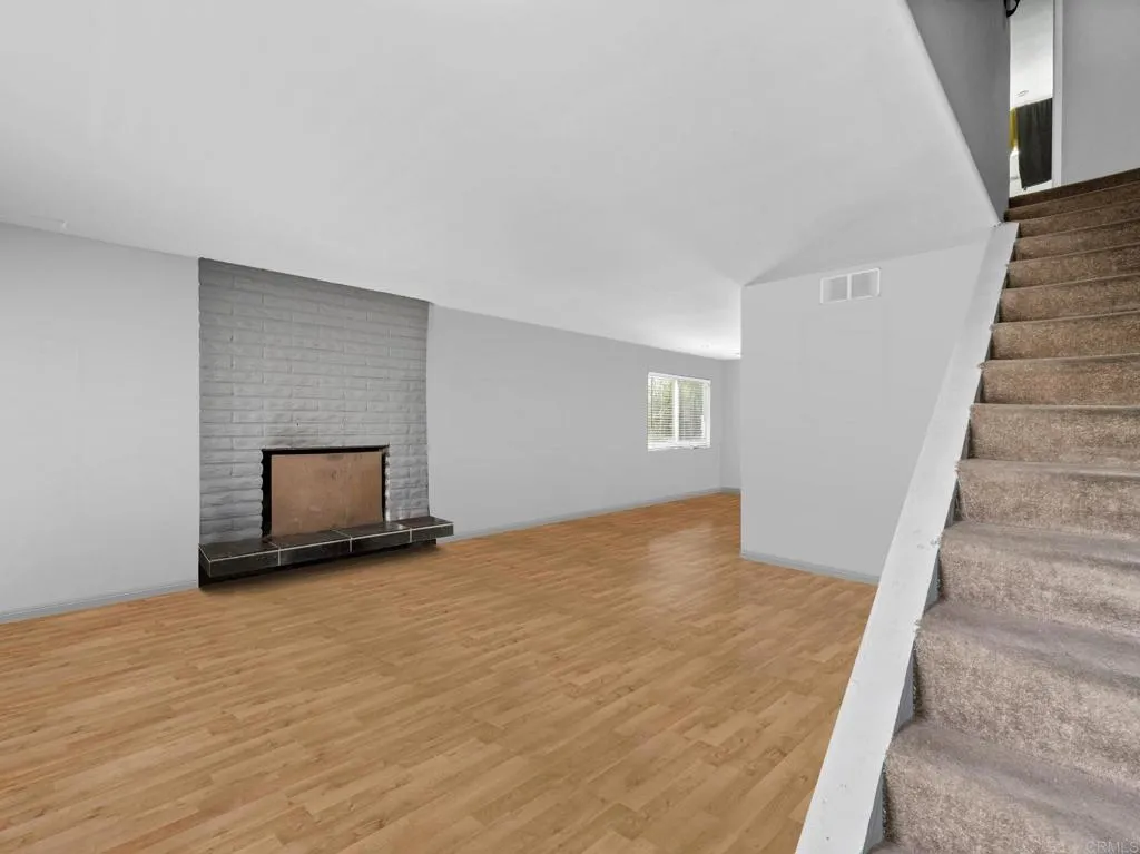 1074 Balour Drive Encinitas, CA 92024 - Photo 7 of 37 a view of an empty room with wooden floor and a fireplace