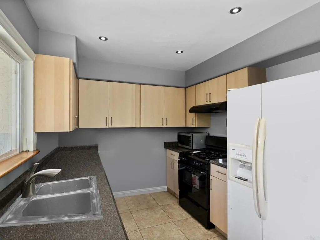 1074 Balour Drive Encinitas, CA 92024 - Photo 9 of 37 a kitchen with stainless steel appliances granite countertop a refrigerator and a sink