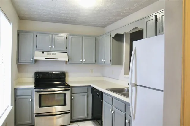 a kitchen with a refrigerator sink and cabinets
