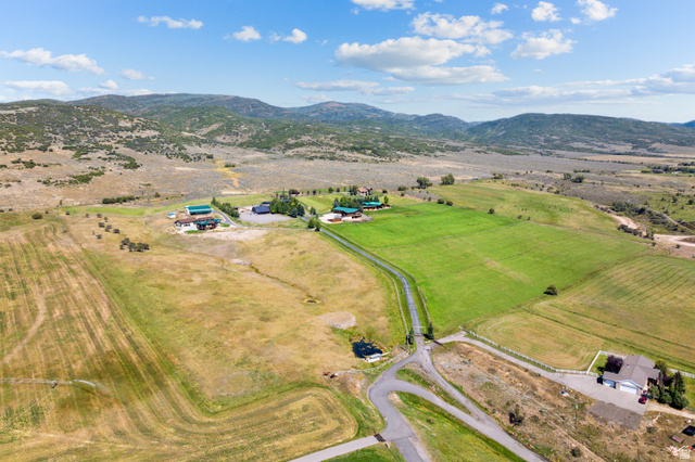 6117 North Rocky Ridge Road Peoa, UT 84061 - Photo 3 of 82 Expansive property featuring a paved driveway, multiple structures, and a pond