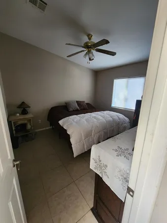 a bedroom with a bed and a ceiling fan
