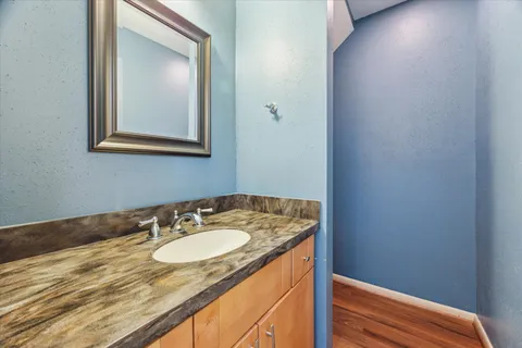 a bathroom with a granite countertop sink and a mirror