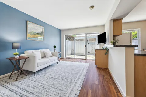 a living room with furniture a flat screen tv and a table
