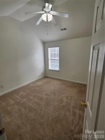 en empty room with windows and ceiling fan
