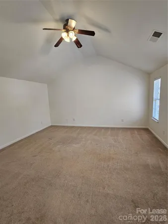 an empty room with fan and windows