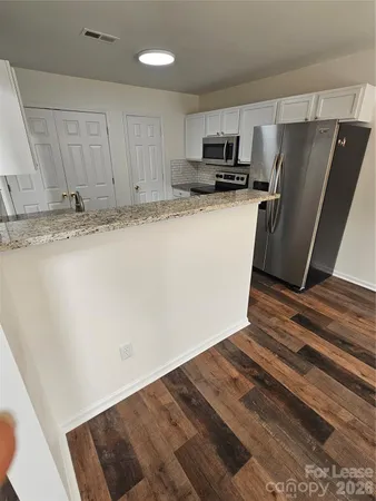 a view of kitchen with refrigerator stove and wooden cabinets