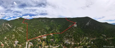 a view of a green field with mountains in the background