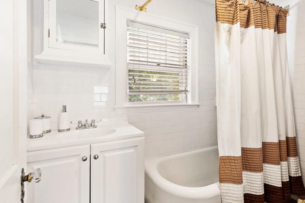 42 Spring Street Wakefield, MA 01880 - Photo 23 of 30 a bathroom with a sink a bathtub and a window