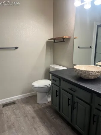 a bathroom with a granite countertop sink a toilet and a mirror