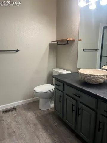 a bathroom with a granite countertop sink a toilet and a mirror