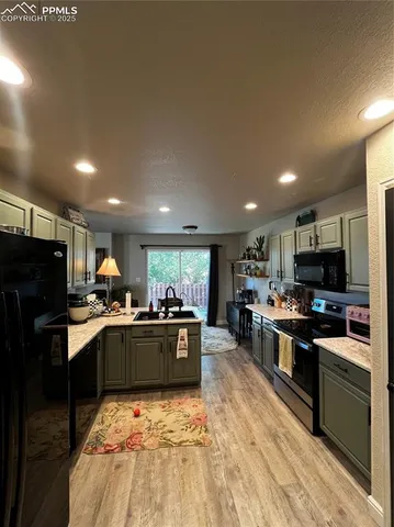 a kitchen with stainless steel appliances kitchen island granite countertop a sink stove and refrigerator