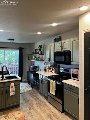 a kitchen with kitchen island a sink stove and microwave