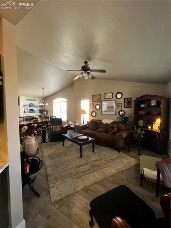 a living room with furniture a rug and a ceiling fan