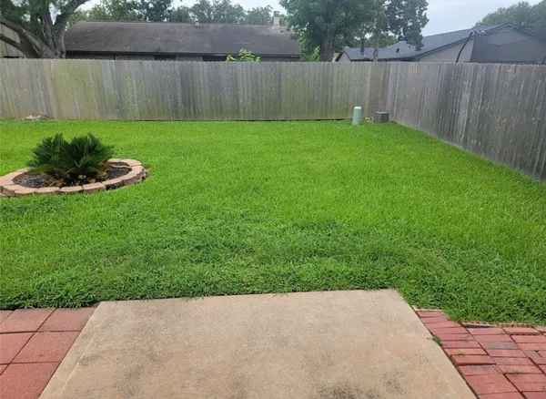 a view of a backyard with a table and a fence