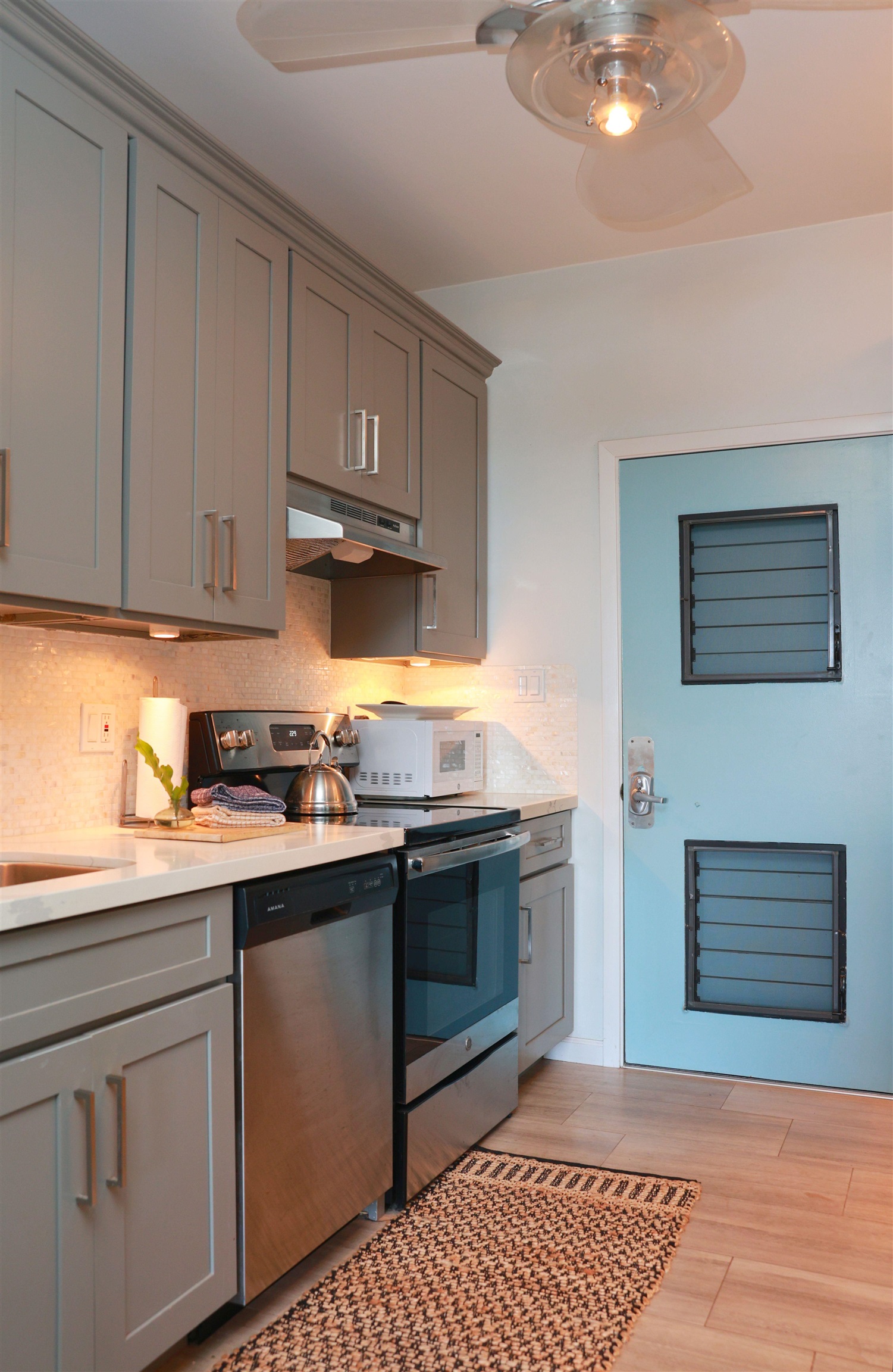 4435 Lower Honoapiilani Road, Unit 205 Lahaina, HI 96761 - Photo 12 of 26 a kitchen with stainless steel appliances granite countertop a stove a sink and a microwave
