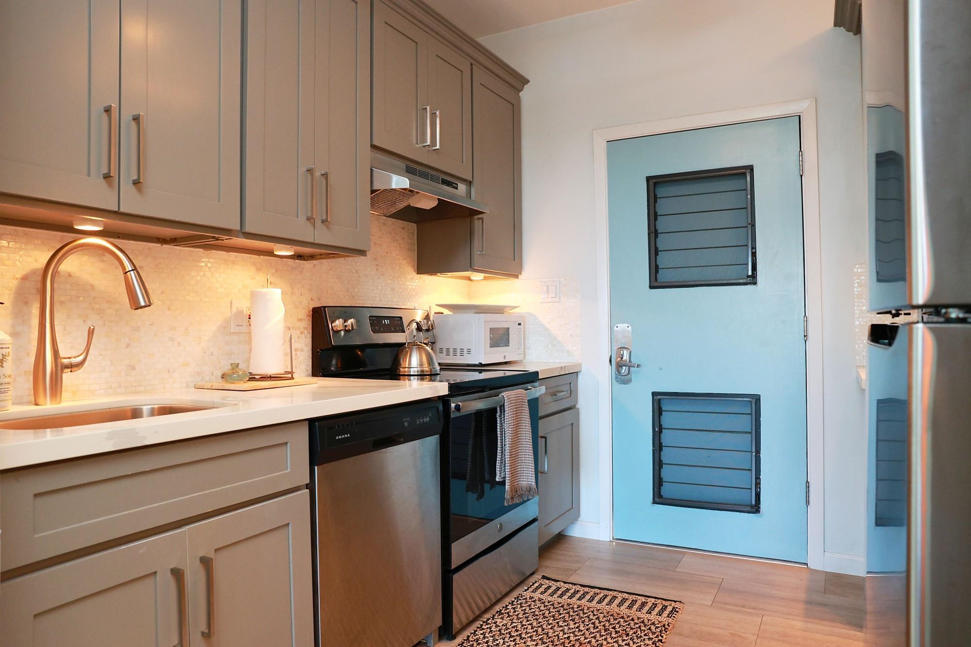 4435 Lower Honoapiilani Road, Unit 205 Lahaina, HI 96761 - Photo 3 of 26 a kitchen with stainless steel appliances granite countertop a stove a sink and a microwave
