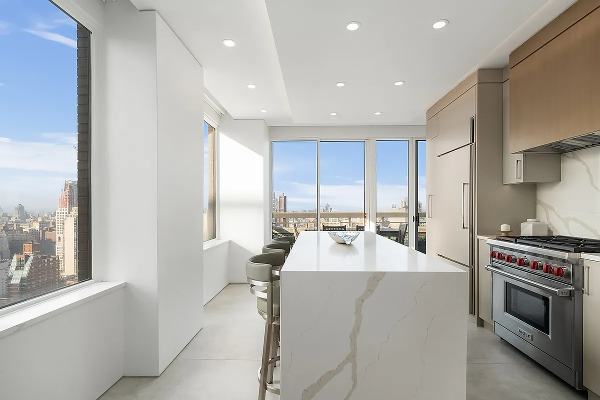 422 East 72nd Street, Unit 37AD Manhattan, NY 10021 - Photo 14 of 58 a large kitchen with stainless steel appliances a stove a sink a refrigerator and a window