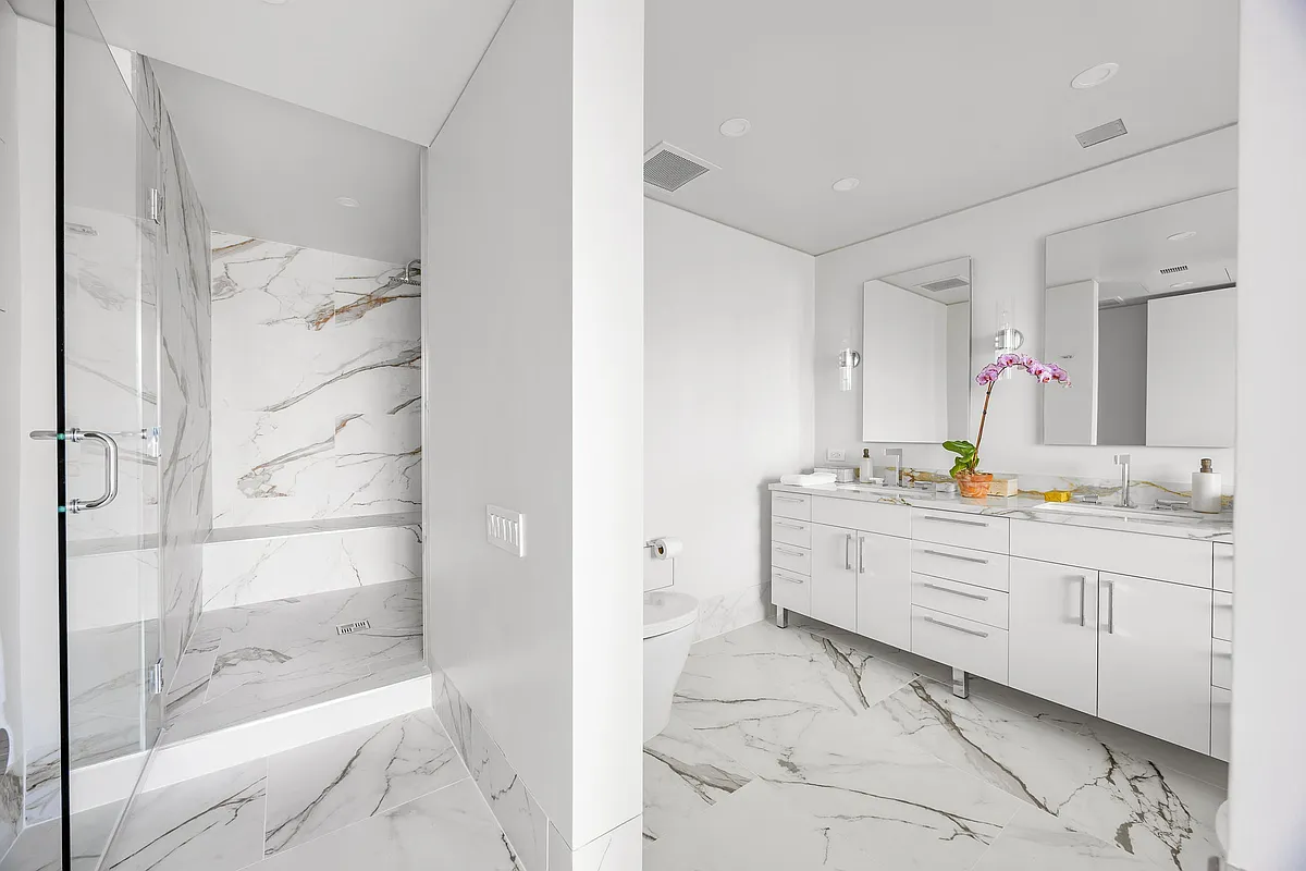 422 East 72nd Street, Unit 37AD Manhattan, NY 10021 - Photo 30 of 58 a bathroom with a granite countertop sink mirror and shower