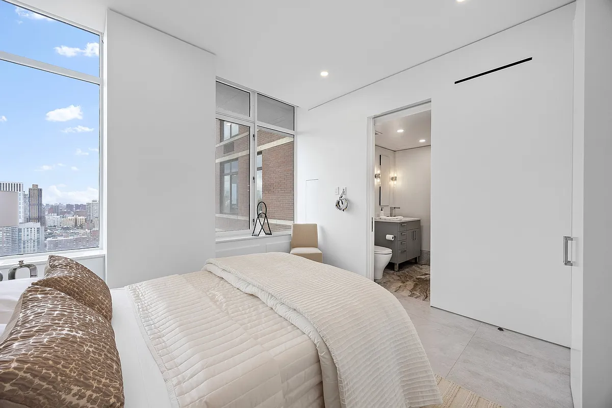 422 East 72nd Street, Unit 37AD Manhattan, NY 10021 - Photo 40 of 58 a bedroom with a bed and a chandelier