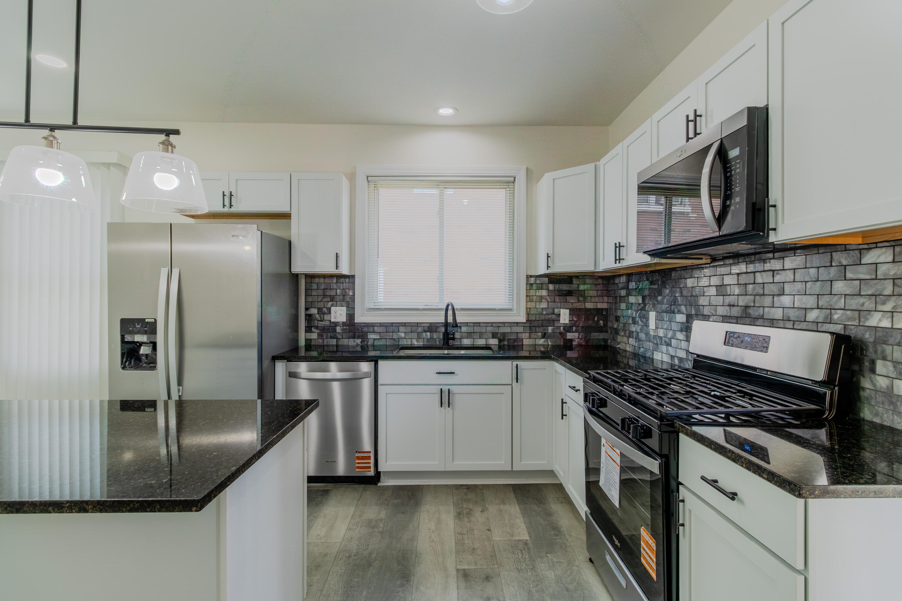 3678 Jackson Street Gary, IN 46408 - Photo 9 of 27 a kitchen with stainless steel appliances granite countertop a stove a sink and a microwave