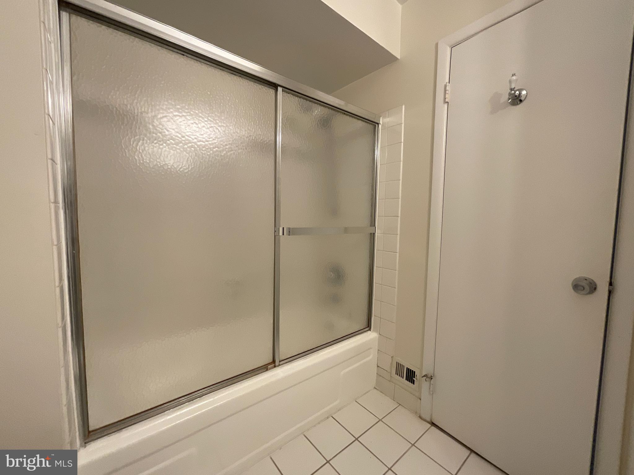 3024 Gentain Court Northeast, Unit 3024 Washington, DC 20017 - Photo 17 of 26 a bathroom with a glass shower door