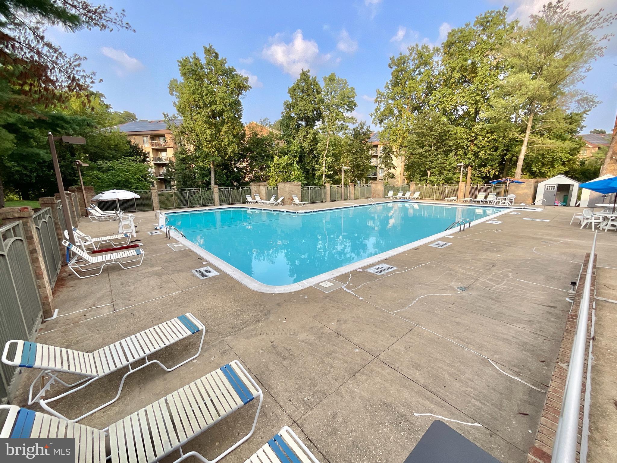 3024 Gentain Court Northeast, Unit 3024 Washington, DC 20017 - Photo 25 of 26 a view of a swimming pool with a patio and fire pit