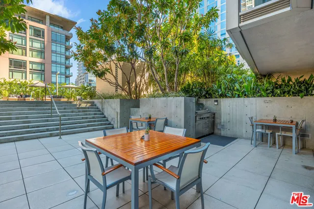 a view of backyard with table and chairs and potted plants