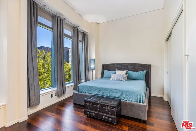 a bedroom with a bed and wooden floor