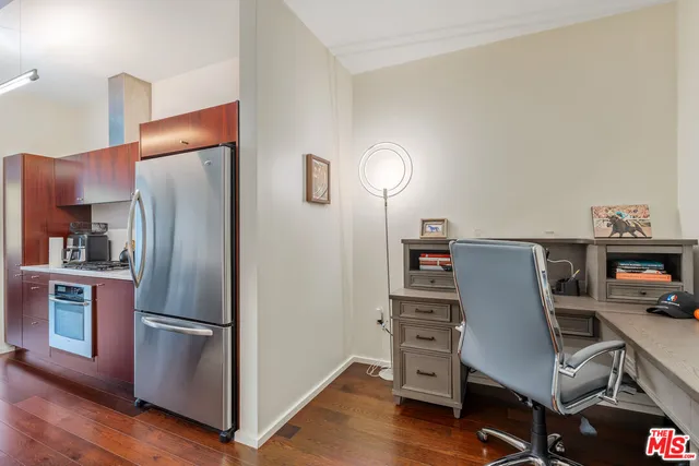 a kitchen with a refrigerator and wooden floor